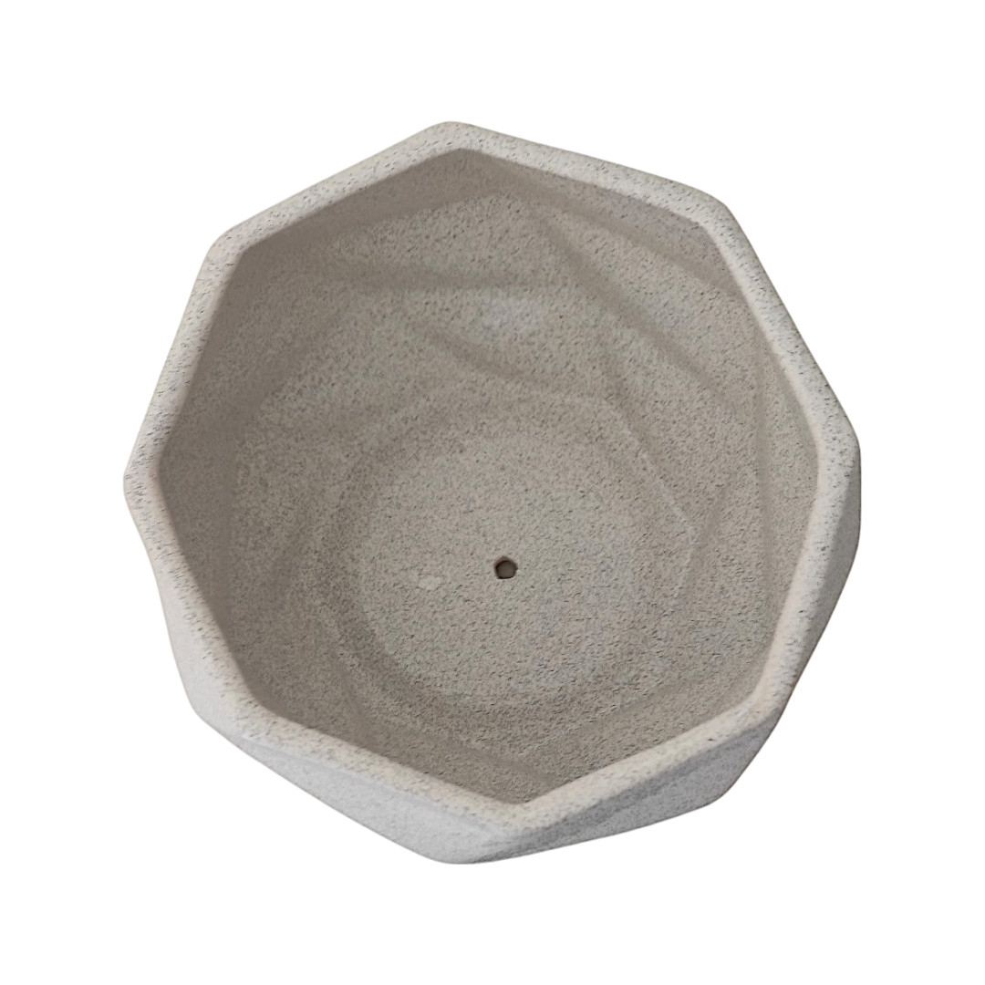 Maceta de cerámica octagonal gris claro con acabado que simula la textura de piedra.