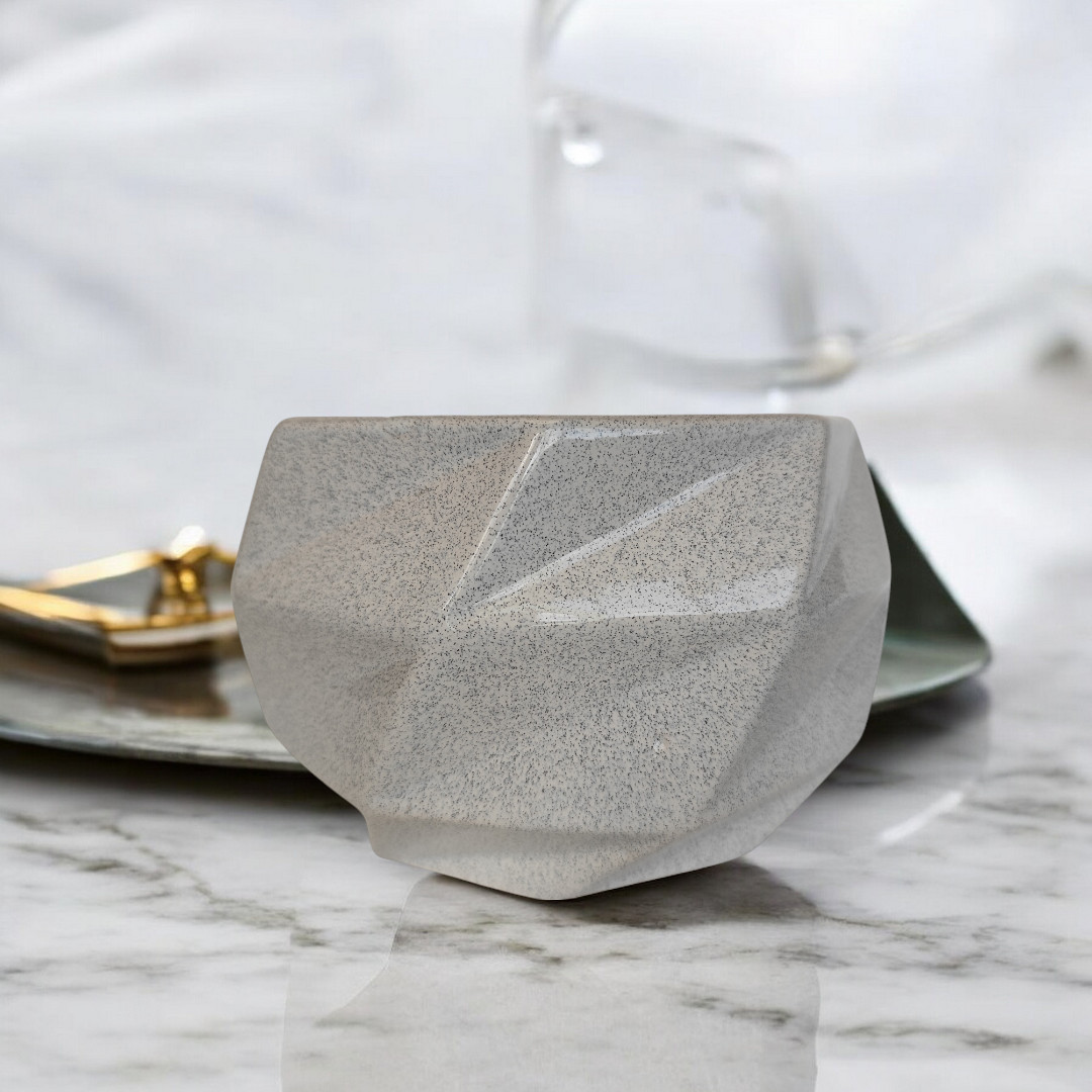 Maceta de cerámica octagonal gris claro con acabado que simula la textura de piedra.